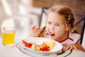 little girl eats because of parent tips for picky eating